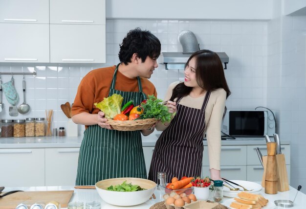 Happy portrait of loving young loving couple asian of having fun standing a cheerful preparing food