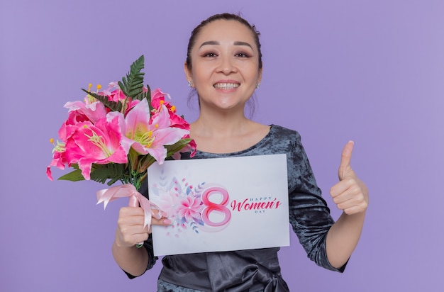 Happy and positive asian woman mother holding bouquet of flowers and greeting card celebrating international womens day march