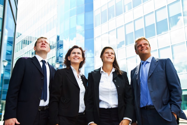 Happy positive business group looking up with dreaming expression 