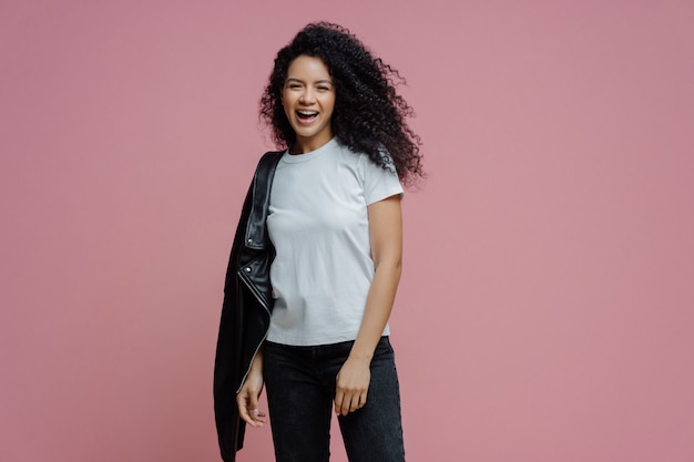 Photo happy positive woman laughs and carries jacket on shoulder