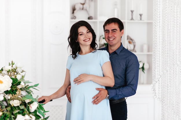 写真 美しい明るいインテリアで幸せな妊娠中のカップル。