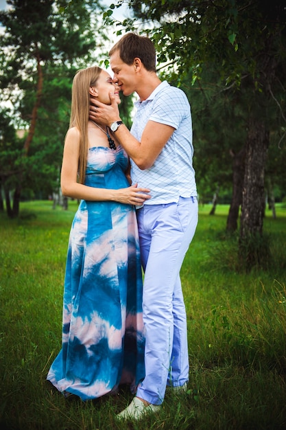 Happy pregnant Couple in the summer park