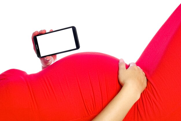 Happy pregnant girl lies on white wall