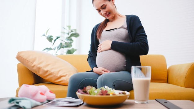 happy pregnant woman eats healthy food for her unborn baby