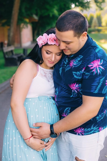 Happy pregnant woman and her husband in the park man and woman