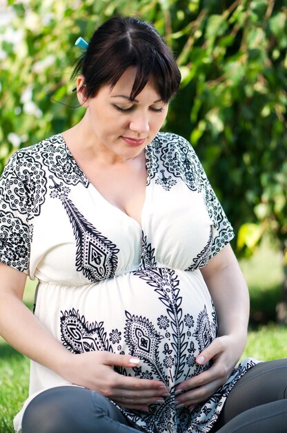 Happy pregnant woman in the park outdoors