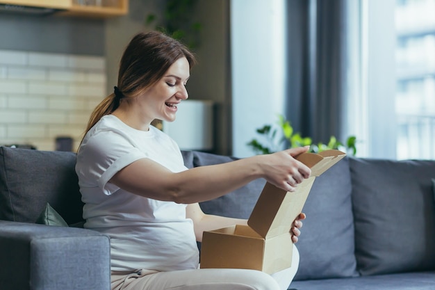 Happy pregnant woman received a parcel cardboard box shopping online