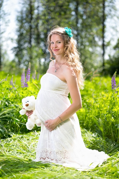 Happy pregnant woman relaxing and enjoying life in nature