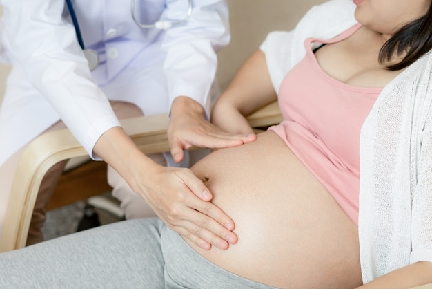 Happy pregnant woman visit gynecologist doctor at hospital or clinic for pregnancy consultant.