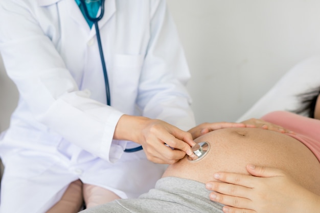 Happy pregnant woman visits gynecologist doctor at hospital