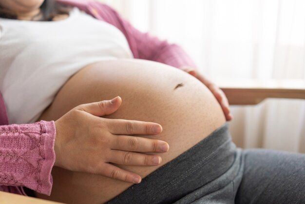 Foto felice donna incinta con il bambino nella pancia incinta. assistenza prenatale alla maternità e gravidanza della donna.