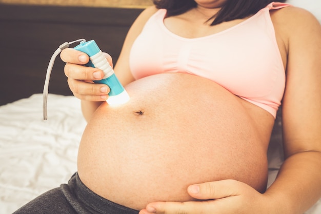 妊娠中のお腹に赤ちゃんを持つ幸せな妊婦