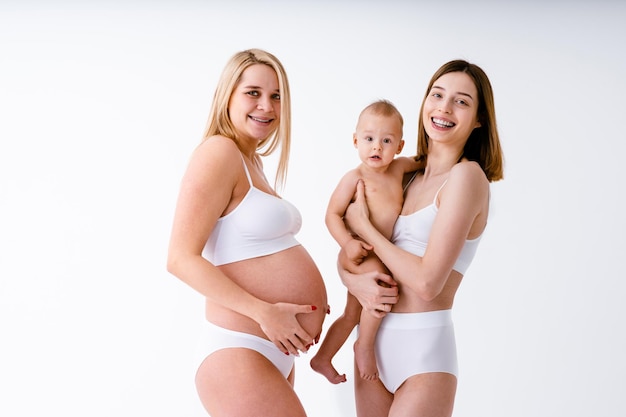 Premium Photo  Happy pregnant woman with big belly on colored background -  young woman wearing underwear expecting a baby - pregnancy, motherhood,  people and expectation concept 