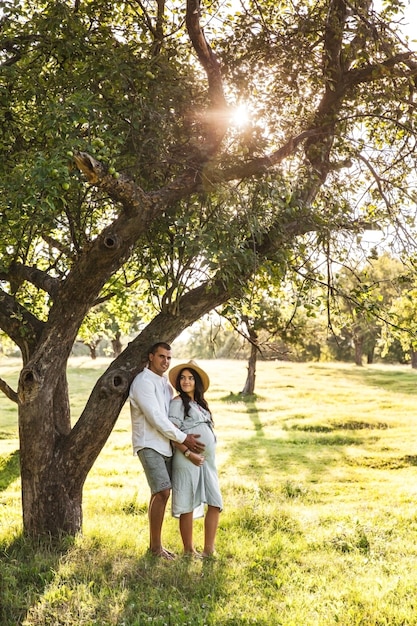 Happy Pregnant woman with her husband at sunset