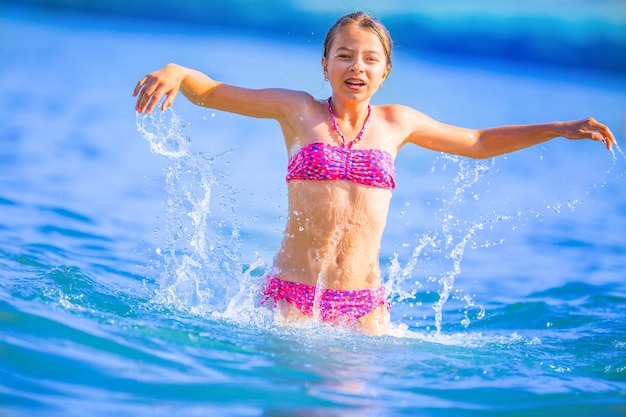 幸せなプレティーンの女の子は休暇の目的地で夏の水と休日を楽しんでいます