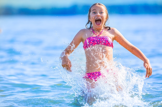 幸せなプレティーンの女の子は休暇の目的地で夏の水と休日を楽しんでいます