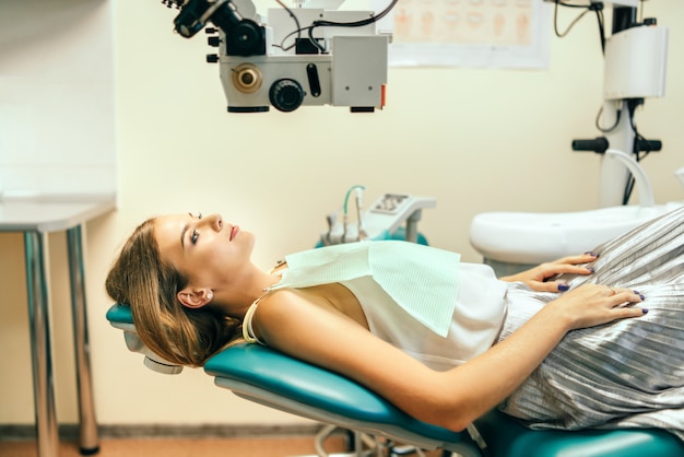 Happy pretty female patient in dental office.