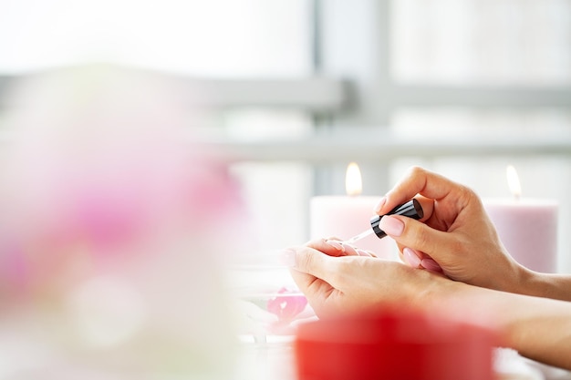 Happy pretty woman making manicure when resting at home.