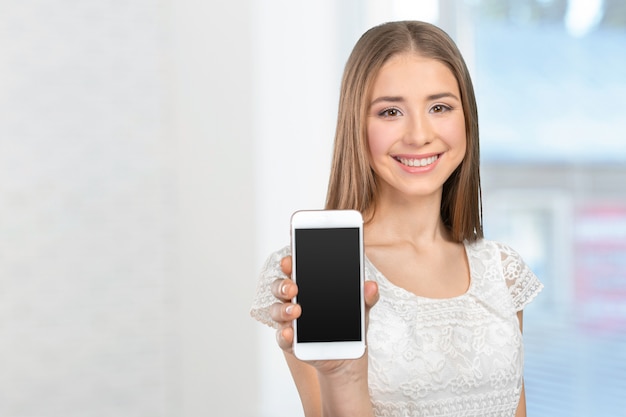 Happy pretty woman showing a blank smart phone screen