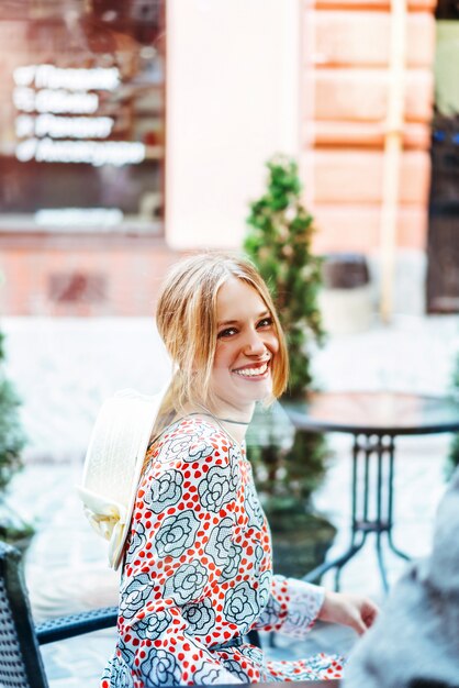 Happy pretty woman sitting in the street cafe