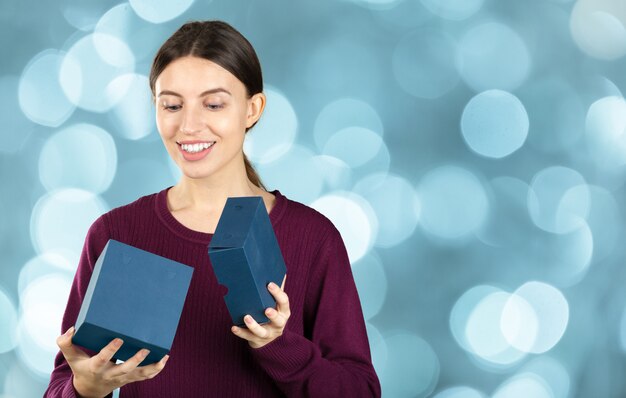 Happy pretty young woman holding gift box