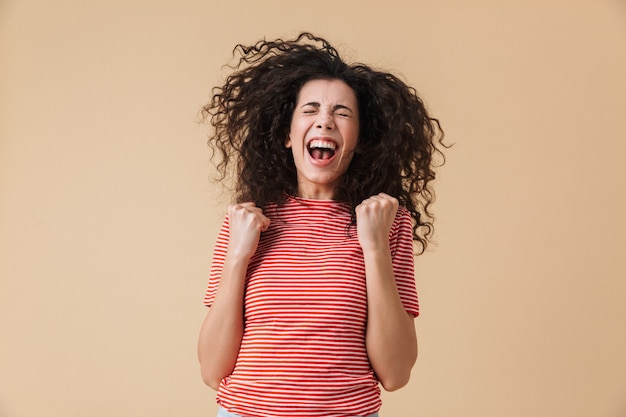 Happy pretty young woman showing winner gesture.