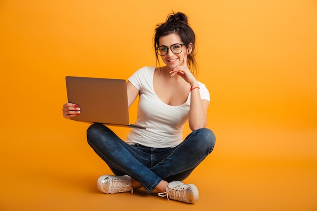 Happy pretty young woman using laptop computer.