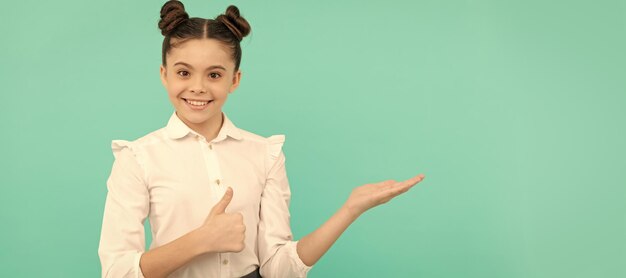 Photo happy primary school girl give thumbs up showing open hand gesture back to school sale shopping child face horizontal poster teenager girl isolated portrait banner with copy space