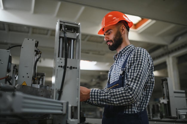 Photo happy professional heavy industry engineer worker wearing uniform and hard hat in a steel factory smiling industrial specialist standing in a metal construction manufacture