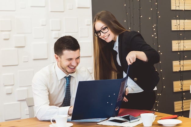 Happy proud successful business couple smiling with folder,looking something