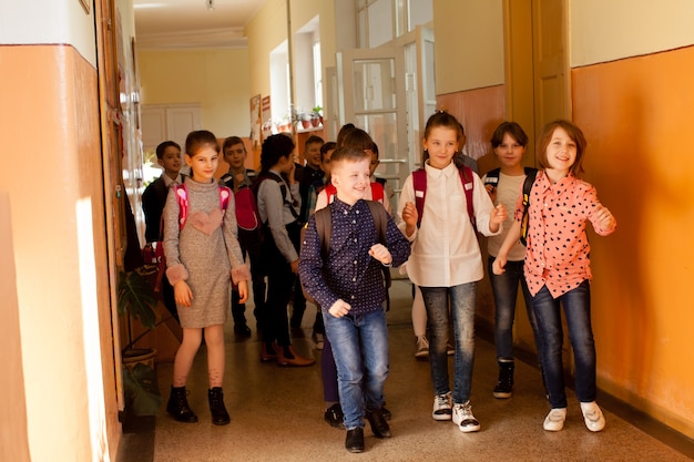 Happy pupils running out of the classroom on summer vacation