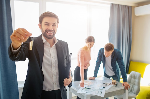 Happy realtor and blurred couple talking at back