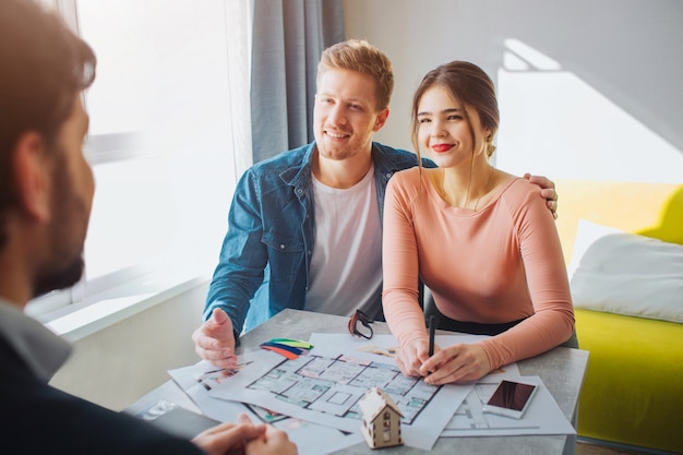 Happy realtor and couple talking