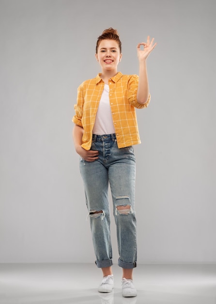 happy red haired teenage girl showing ok hand sign