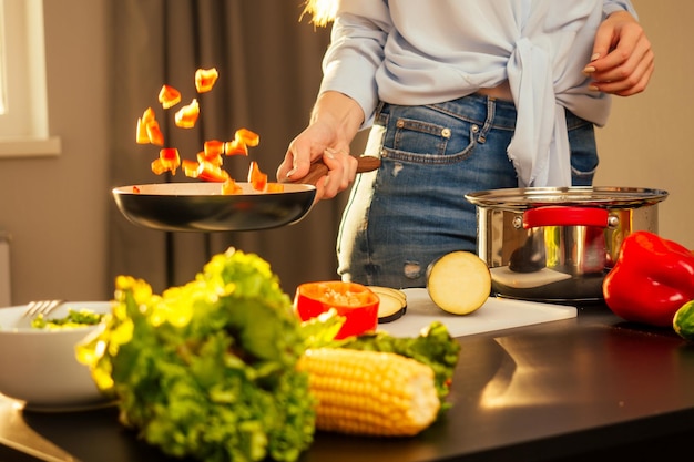 Happy redhaired ginger woman cooking in evening sun lights sunset background.