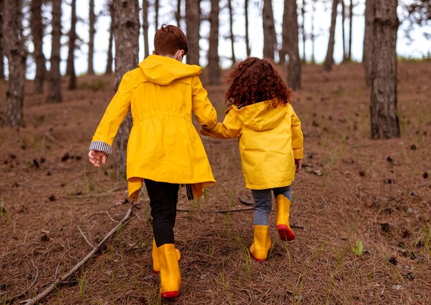 Happy redhead boy and girl in raincoats