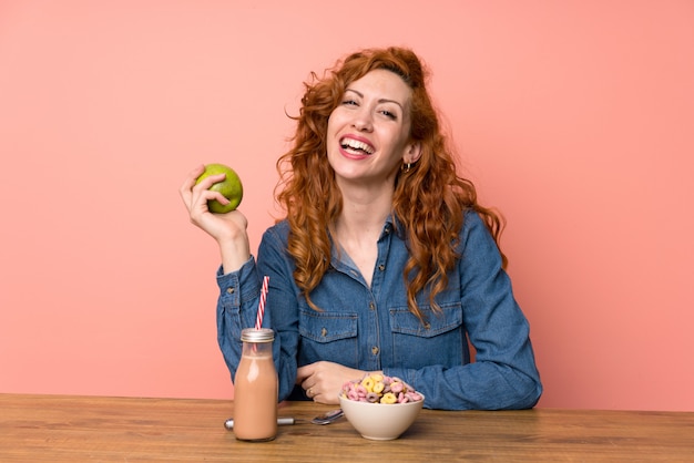 Donna rossa felice facendo colazione