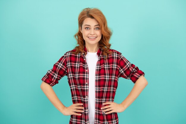 Happy redhead woman with curly hair in checkered casual shirt, style.