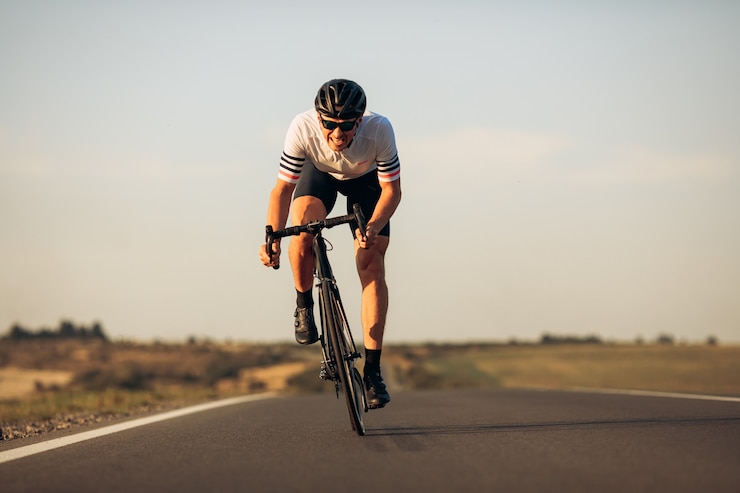 Photo happy road cyclist in protective helmet and mirrored glasses enjoying morning biking on fresh air