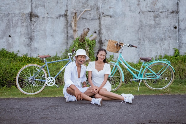 Foto la coppia romantica felice con le biciclette si siede insieme sul ciglio della strada