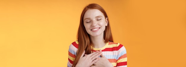 Photo happy romantic delighted sighing young lovely redhead girlfriend smiling broadly touching heart