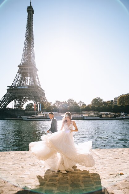 Coppia sposata romantica felice che abbraccia vicino alla torre eiffel a parigi