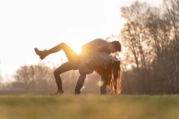 Scena felice e romantica con giovani coppie eterosessuali che ballano e giocano in un parco il giorno di san valentino