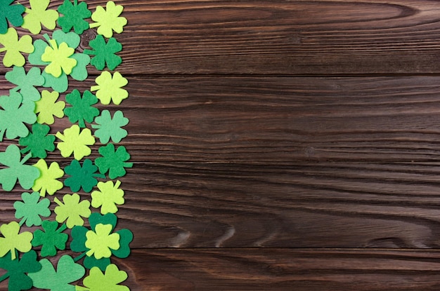 Happy Saint Patrick's mockup of handmade felt shamrock clover leaves on wooden background.