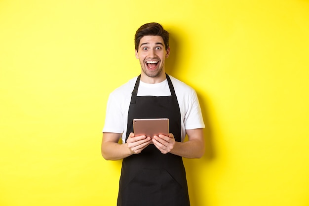 Happy salesman in black apron