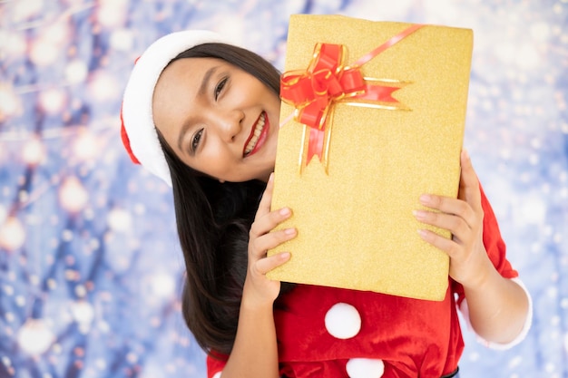 Happy Santa Claus-meisje houdt de huidige doos met sneeuwachtergrond vast.