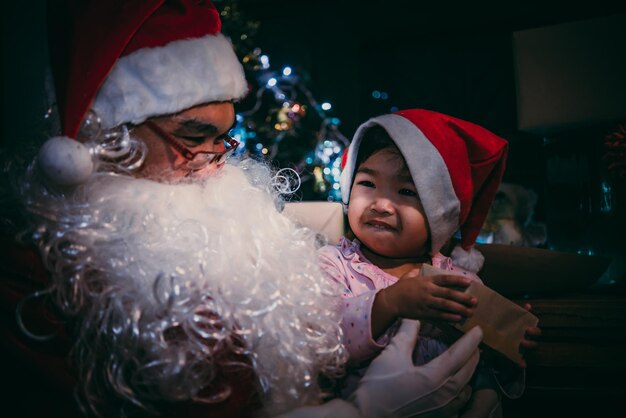 Happy santa clause with little girl on decorate christmas backgroundThailand peopleMerry x'mas