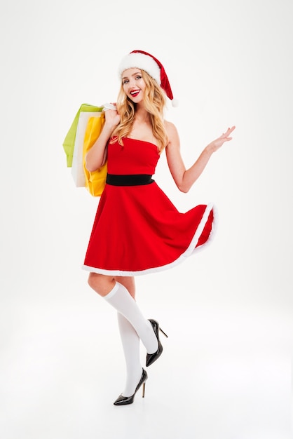 Счастливая девушка Санта с хозяйственными сумками