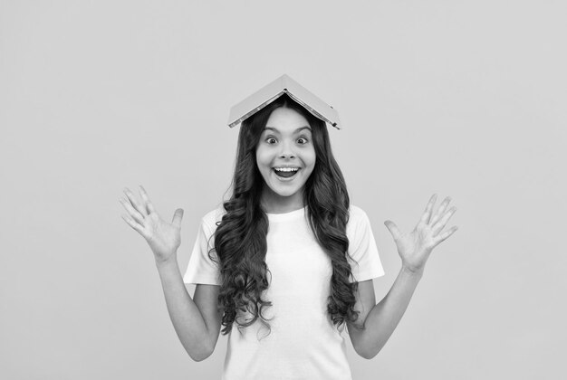 Photo happy school child ready to study with notepad on head school