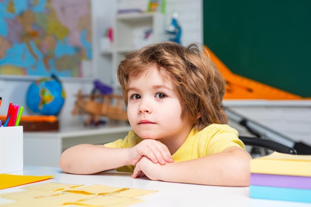 Happy school kids at lesson Friendly child in classroom near blackboard desk